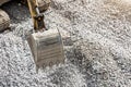Excavator bucket close up against a background of gray crushed stone. Royalty Free Stock Photo
