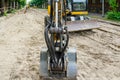 Excavator bucket closeup at street reconstruction site, dismantled street surface