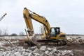 Excavator with bucket at demolition of tall building. Hydraulic machine for demolish. Backhoe destroys concrete of the old Royalty Free Stock Photo