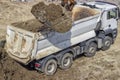 Excavator bucket full of dirt and truck Royalty Free Stock Photo