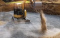 Excavator bucket moving gravel stones for foundation building Royalty Free Stock Photo