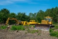 Excavator and bulldozer clearing forest land.