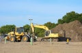Excavator and bulldozer at a construction site with a large pile of dirt Royalty Free Stock Photo