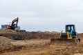 Excavator and a bulldozer work at a construction site. Land clearing, grading, pool excavation, utility trenching and foundation Royalty Free Stock Photo