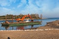 Excavator for channel dredge on a barge.