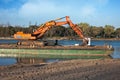 Excavator for channel dredge on a barge