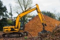 Excavator with Clamshell Grab Bucket used to move wood chips