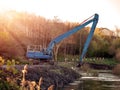 Excavator cleaning and deepening small river.