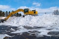 Excavator clearing snow side on