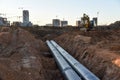 Excavator during construction of main water supply pipeline. Laying underground storm sewers at construction site. Water main Royalty Free Stock Photo