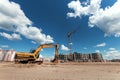 Excavator at a construction site against the background of a tower crane. Construction, technology Royalty Free Stock Photo