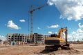Excavator at a construction site against the background of a tower crane. Construction, technology Royalty Free Stock Photo