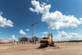 Excavator at a construction site against the background of a tower crane. Construction, technology Royalty Free Stock Photo