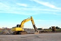 Excavator on a construction site cuts and crumbles old concrete and asphalt. Hydraulic breaker grinder.