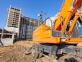 Excavator at the construction site of a multi-storey building, fragment