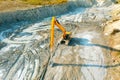 An excavator at a construction site plans the ground before work on the foundation