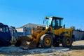 Excavator on the construction site is preparing to load the soil into the dump truck. Wheel loader with iron bucket Royalty Free Stock Photo