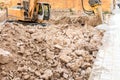 Excavator crushing rocks to start construction of houses in a town in Spain