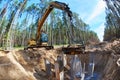 Excavator cutting concrete pole during foundation construction Royalty Free Stock Photo