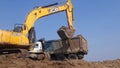 An Excavator cutting soil moorum and loading in a dump truck - Dump truck carrying soil moorum