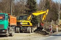 Excavator delivers construction waste to the truck. Cleaning the site for new construction. Construction works. Landscape design