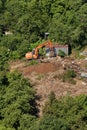 Excavator demolishes illegal buildings in the forest
