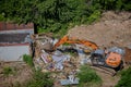 Excavator demolishes old buildings in the forest. Destroy of an illegally built old building in nature - Moscow, Russia, June 26,
