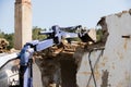 Excavator demolishing a concrete wall