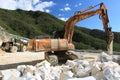 Excavator with demolition hammer in a Carrara marble quarry. A l