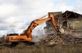 Excavator during demolition the house in the rural. Renovation old home and construction project. Backhoe demolishes building. Royalty Free Stock Photo