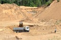 Excavator developing the sand on the opencast and loading it to the heavy dump truck. Royalty Free Stock Photo