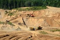 Excavator developing the sand on the opencast and loading it to the heavy dump truck. Processing of loose material in mining