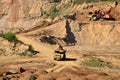 Excavator developing the sand on the opencast and loading it to the heavy dump truck. Processing of loose material in mining