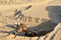 Excavator developing the sand on the opencast and loading it to the heavy dump truck. Processing of loose material in mining Royalty Free Stock Photo