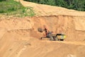 Excavator developing the sand on the opencast and loading it to the heavy dump truck. Processing of loose material in mining