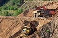 Excavator developing the sand on the opencast and loading it to the heavy dump truck. Processing of loose material in mining Royalty Free Stock Photo