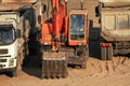 Excavator digger and dump trucks at a construction site Royalty Free Stock Photo