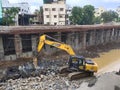 Excavator digging and breaking stones in underground construction site