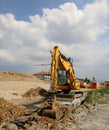 Excavator digging  the dirt area at the edge of the construction site Royalty Free Stock Photo