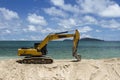 Excavator Is Scooping Up Sand On The Beach With Sky, Sea And Island Background..Excavator Is Digging Sand On The Beach