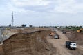 Excavator is digging to build the city road which is next to the highway bridge. And dump trucks carry soil at the construction