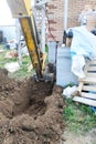 The excavator digging a trench near a cable house for a small bucket Royalty Free Stock Photo