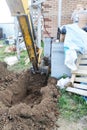 The excavator digging a trench near a cable house for a small bucket Royalty Free Stock Photo