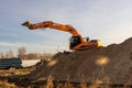 Excavator digging trench using dump truck. earthworks at construction site. heavy earth mover machine