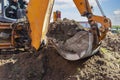 The excavator digs a deep foundation pit. Close-up. Earthwork at a construction site Royalty Free Stock Photo