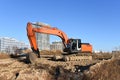 Excavator digs dirt during groundwork at construction site. Heavy machinery and earth-moving equipment for earthwork