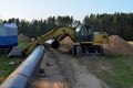 Excavator digs ground for the installation of industrial gas and oil pipes. Natural gas pipeline construction work.