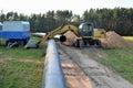 Excavator digs ground for the installation of industrial gas and oil pipes. Natural gas pipeline construction work.