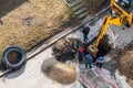 An excavator digs a trench to repair a pipeline on a city street