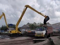 Excavator discharge coal to truck at jetty